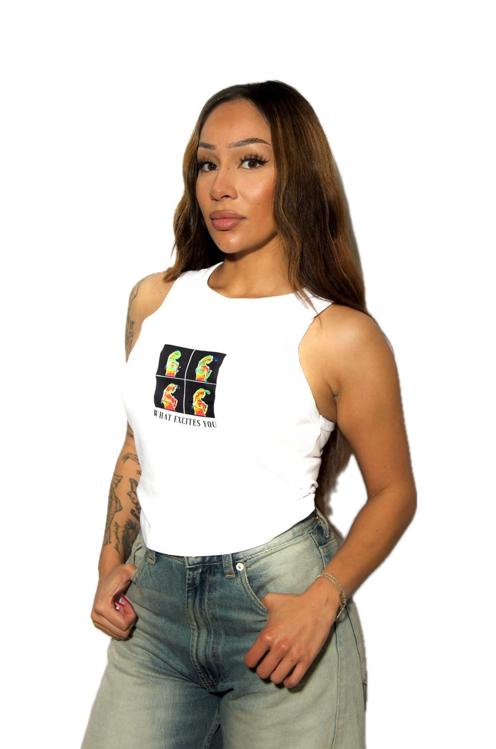 Woman wearing a white tank top with a colorful graphic and text, paired with light blue jeans on a white background.