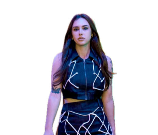 Woman wearing a black outfit with white geometric patterns on a white background