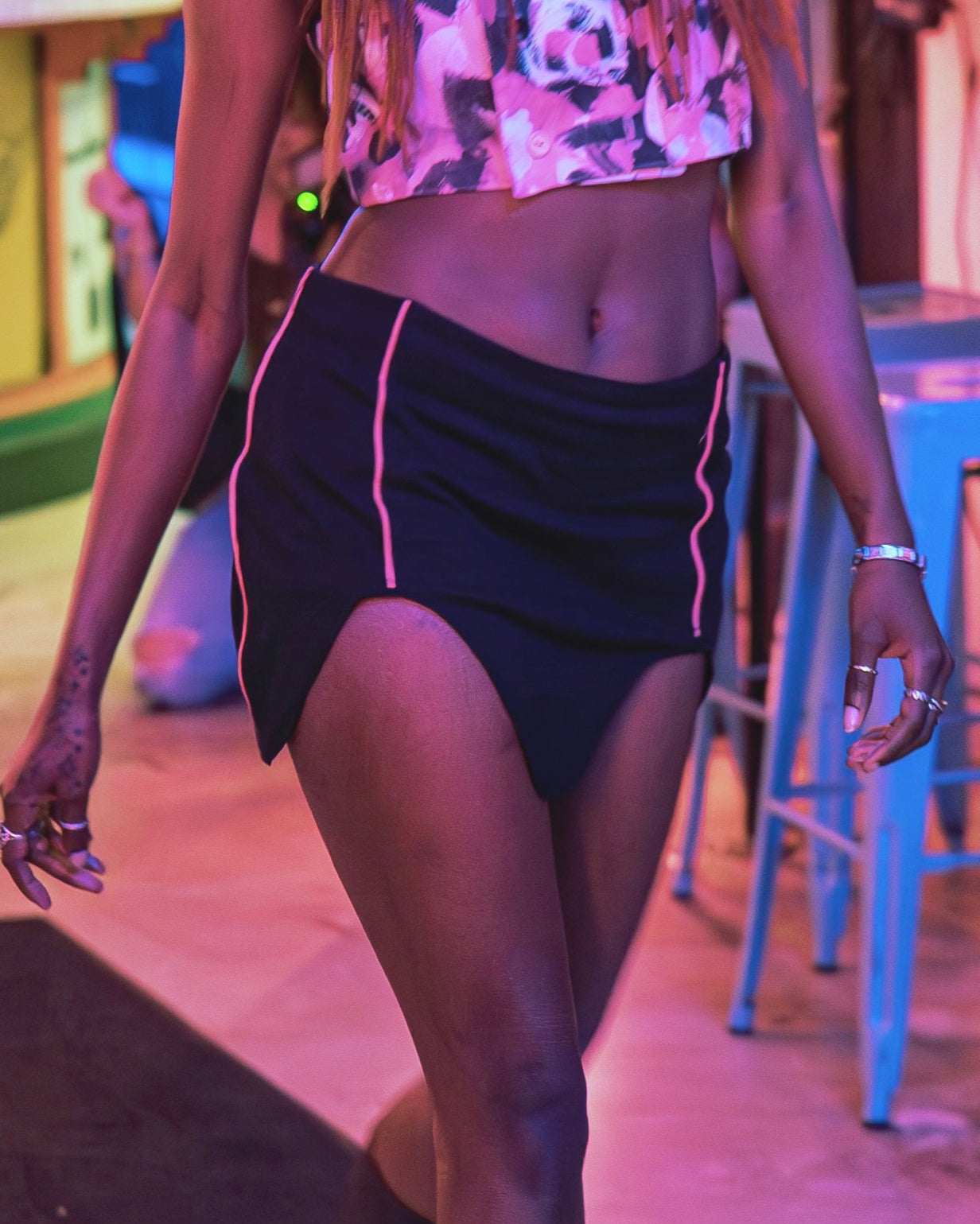 Woman walking in a bar with neon lights and decor